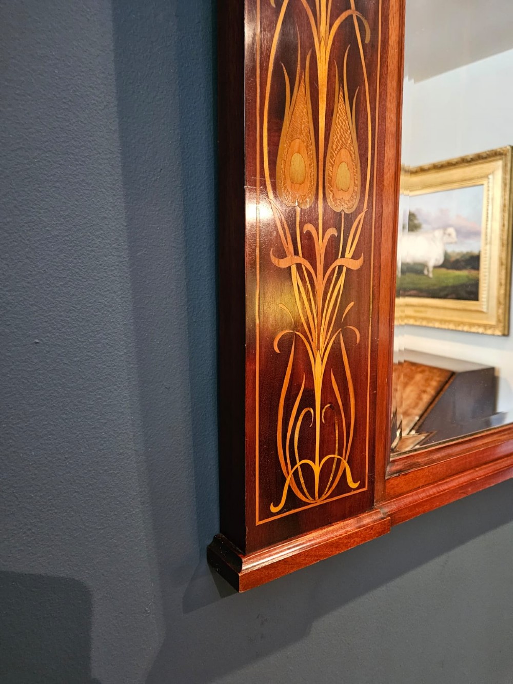 An Edwardian rectangular mahogany wall mirror featuring decorative marquetry side panels with stylised floral motifs and a corbelled top cornice. View VIII