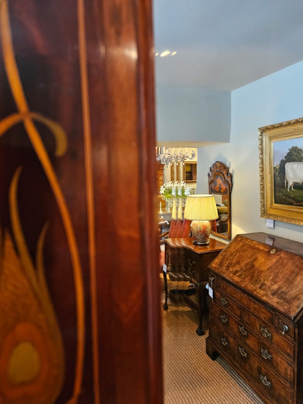 An Edwardian rectangular mahogany wall mirror featuring decorative marquetry side panels with stylised floral motifs and a corbelled top cornice. View IX
