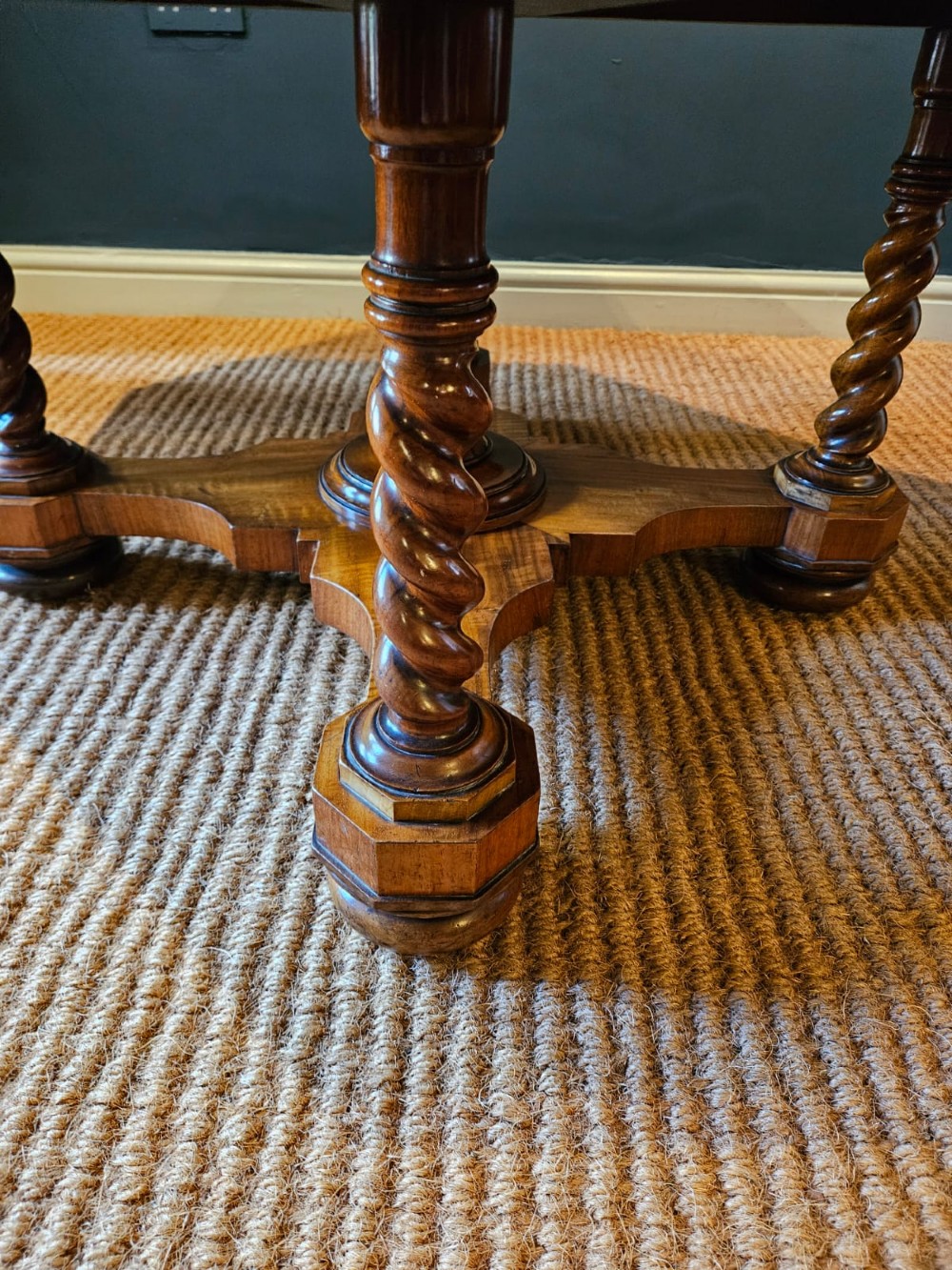 An octagonal burr walnut low coffee table featuring light wood stringing inlay, four barley twist support legs, and a central turned column on a quadruped base. View II