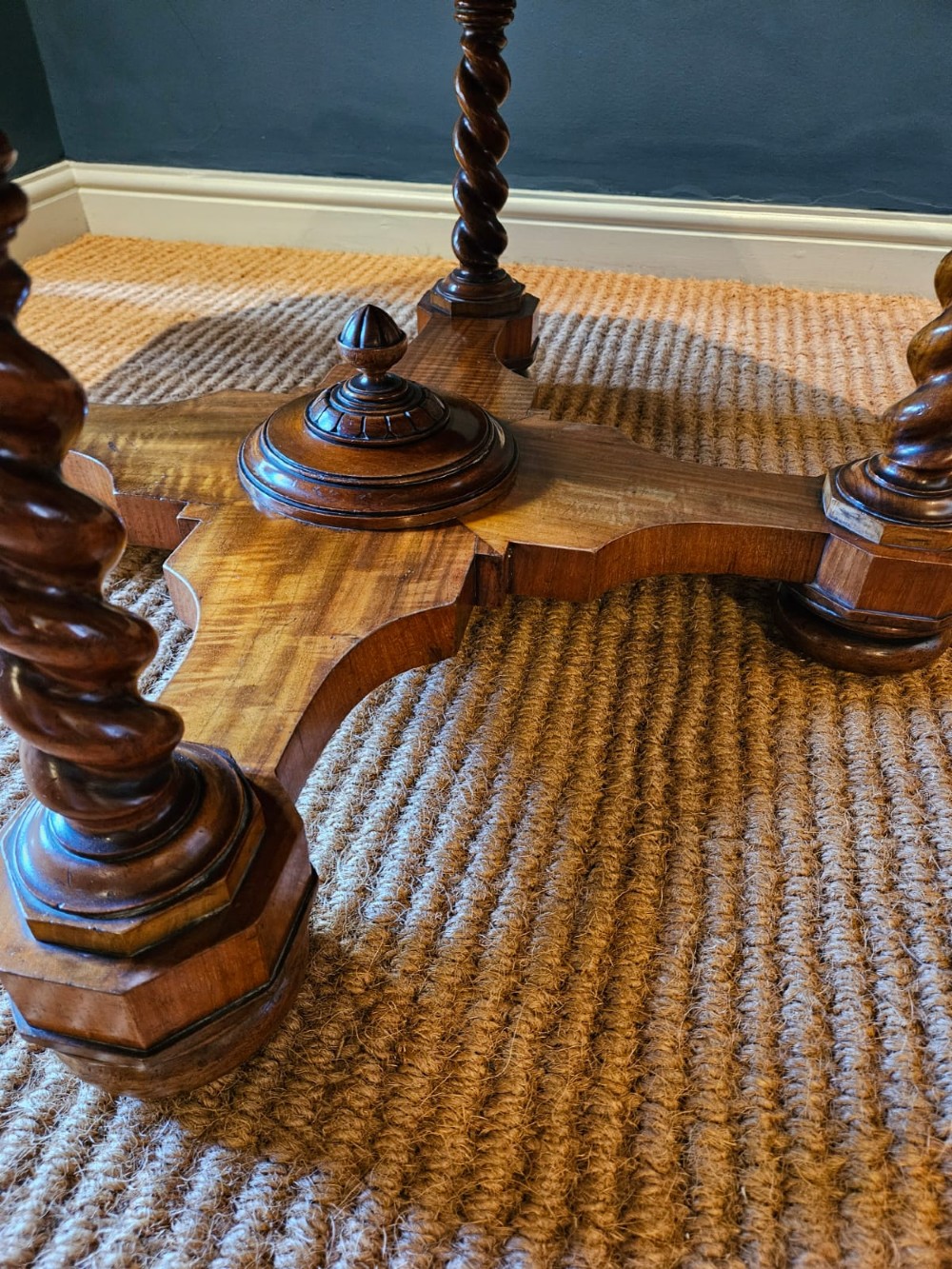 An octagonal burr walnut low coffee table featuring light wood stringing inlay, four barley twist support legs, and a central turned column on a quadruped base. View III