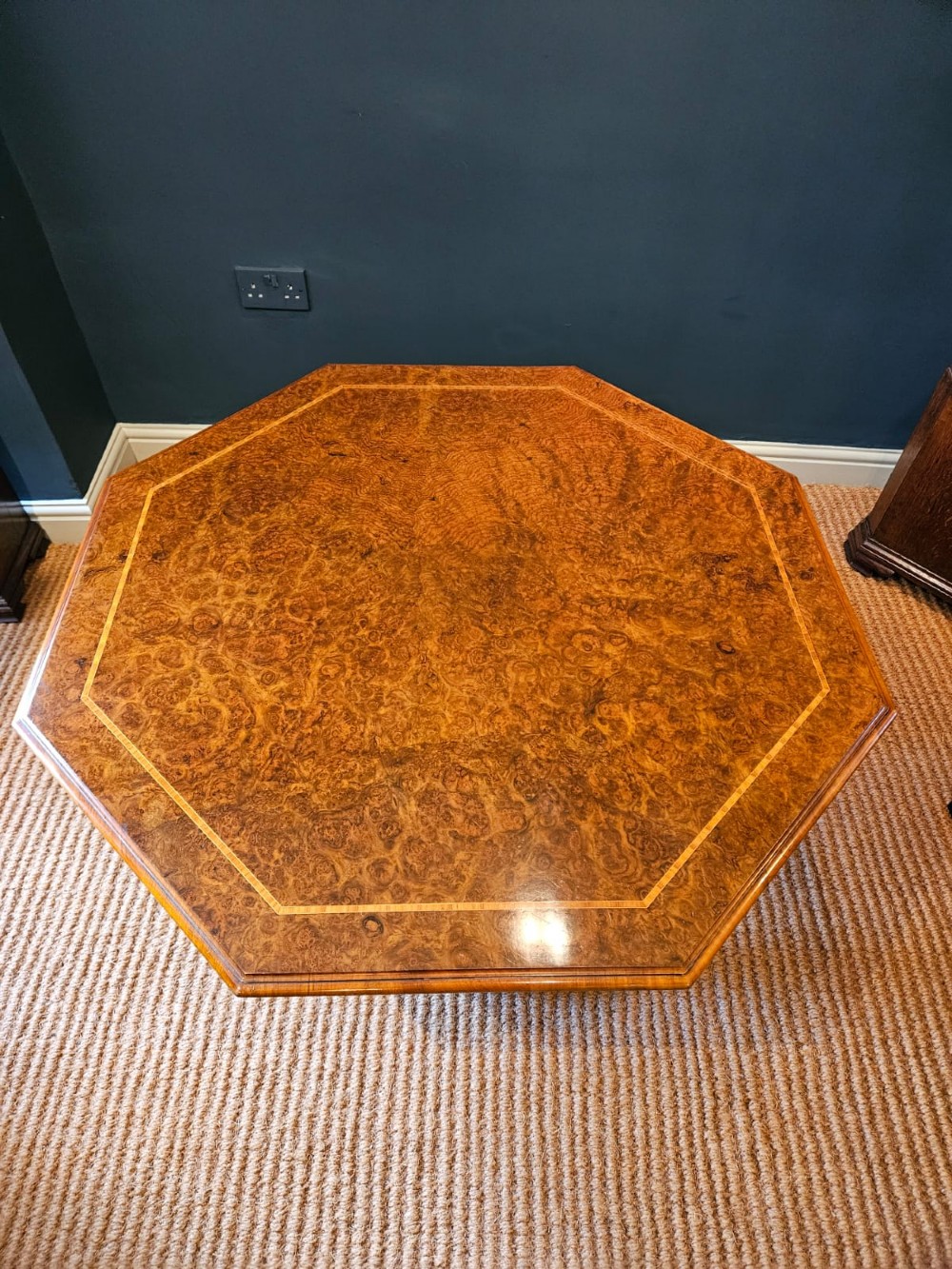 An octagonal burr walnut low coffee table featuring light wood stringing inlay, four barley twist support legs, and a central turned column on a quadruped base. View V