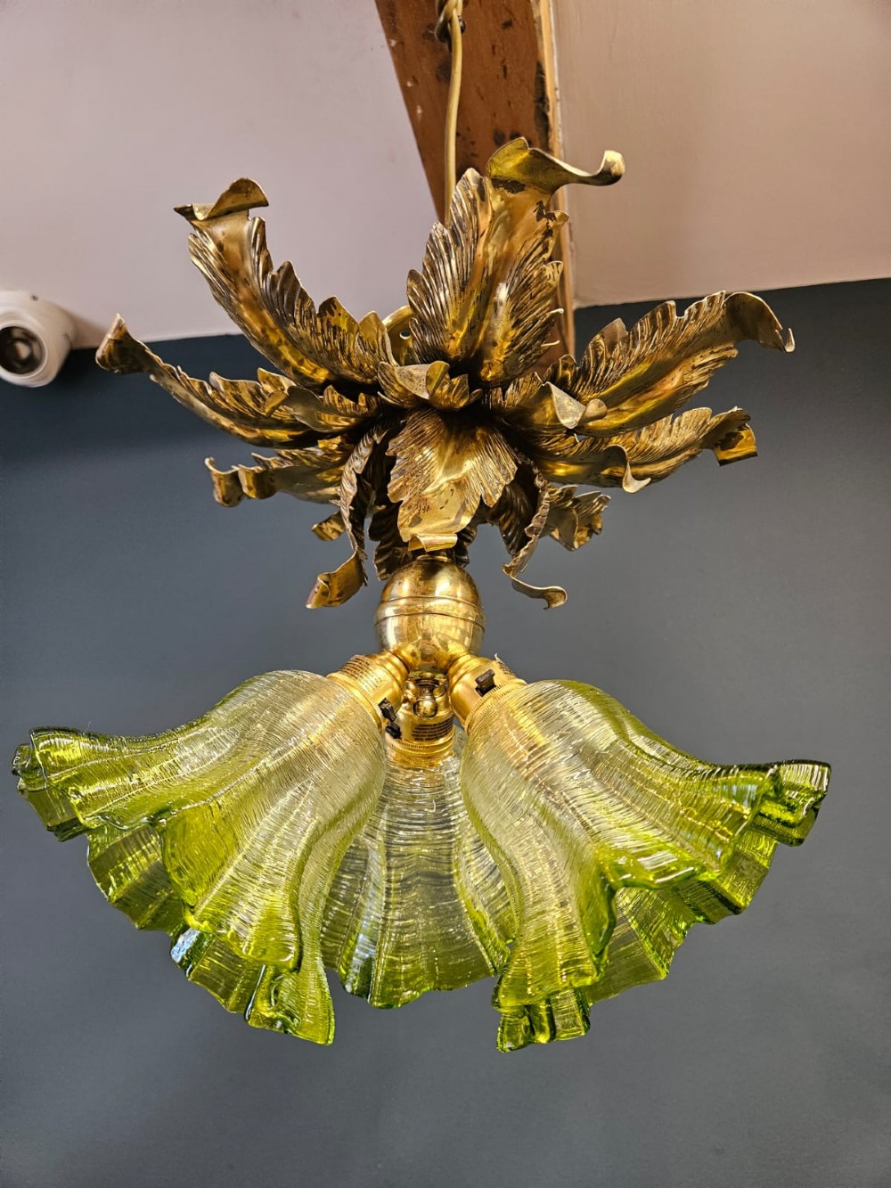Victorian ceiling light featuring cast brass leaf motifs around the ceiling mount above fluted green glass shades. View II