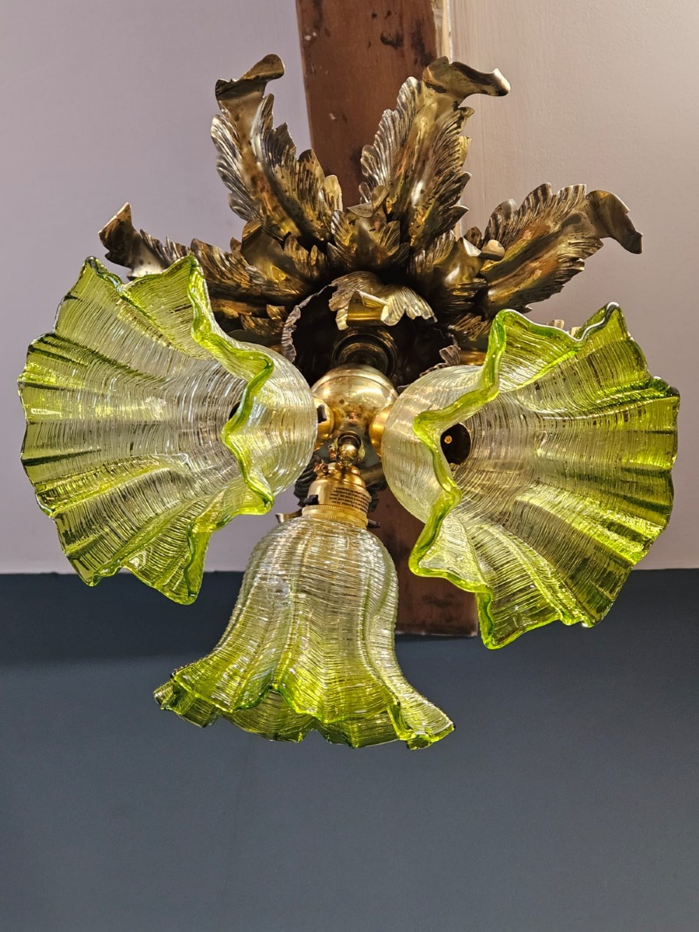 Victorian ceiling light featuring cast brass leaf motifs around the ceiling mount above fluted green glass shades. View III