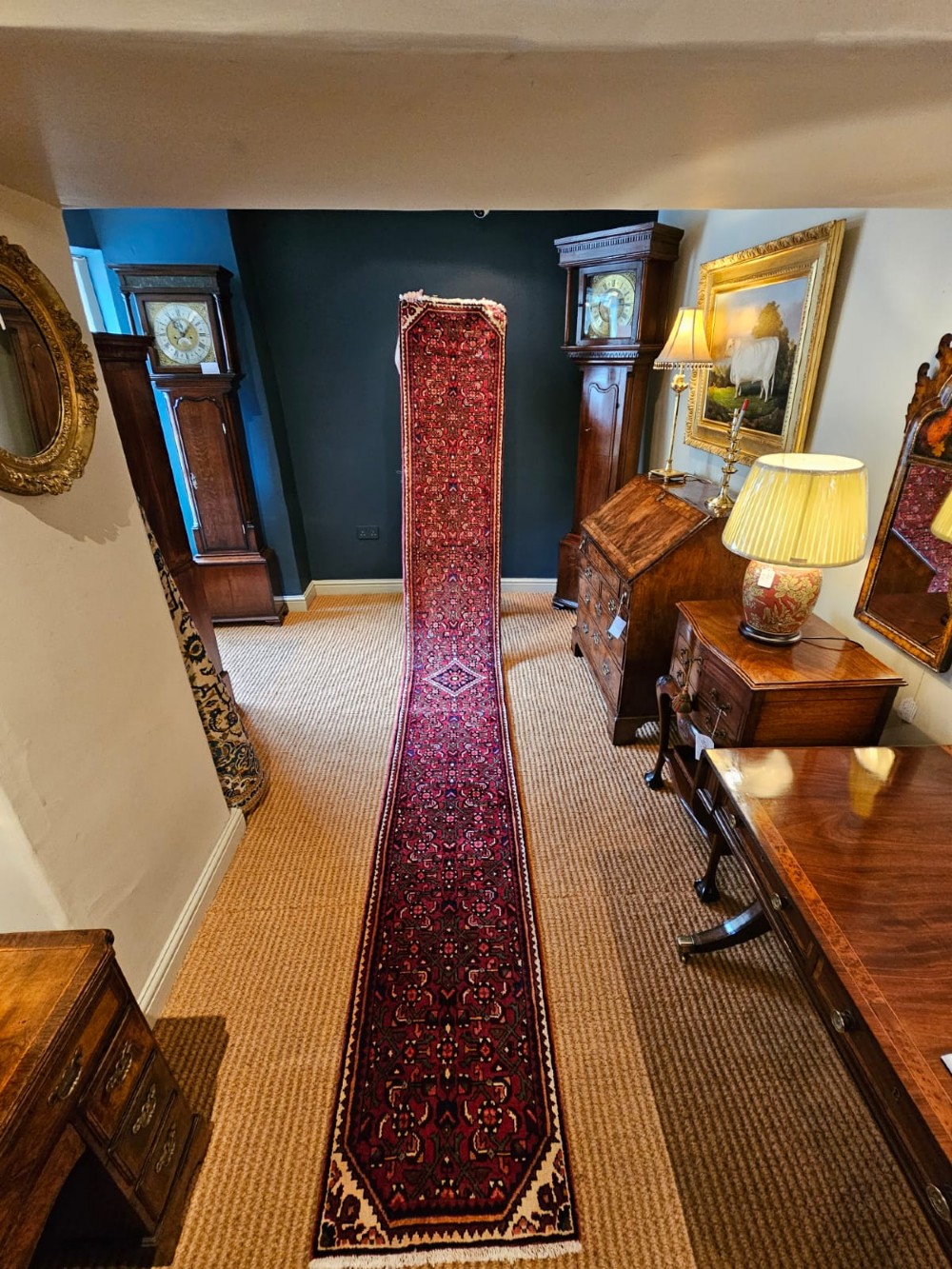 An extra-long wool hallway runner rug featuring intricate Persian geometric and floral patterns in deep red, navy blue, and cream with fringed ends.
