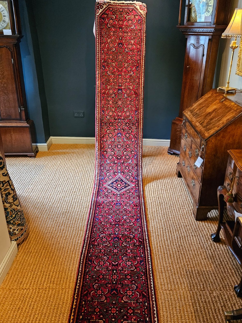 An extra-long wool hallway runner rug featuring intricate Persian geometric and floral patterns in deep red, navy blue, and cream with fringed ends. View II
