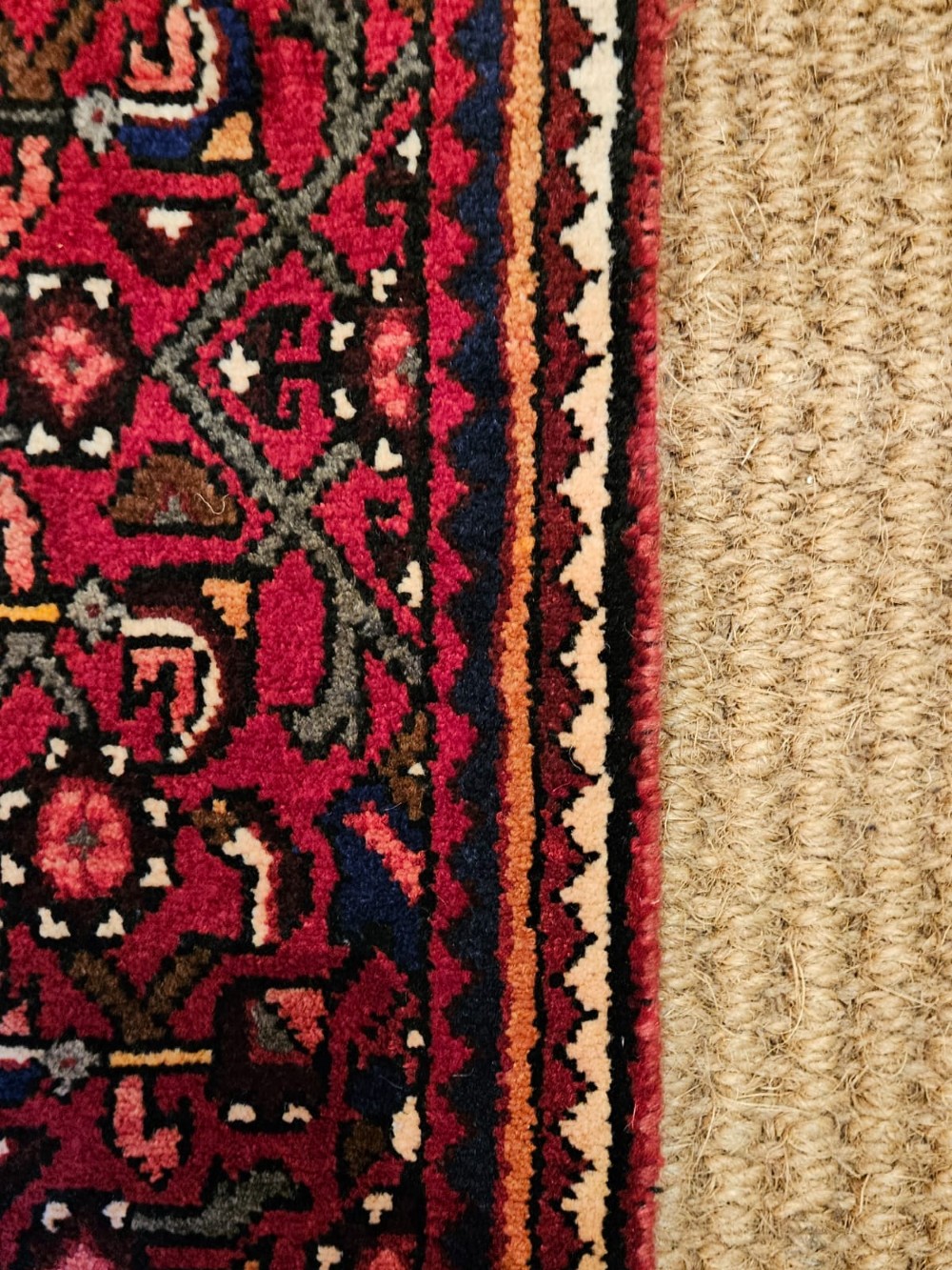An extra-long wool hallway runner rug featuring intricate Persian geometric and floral patterns in deep red, navy blue, and cream with fringed ends. View VI