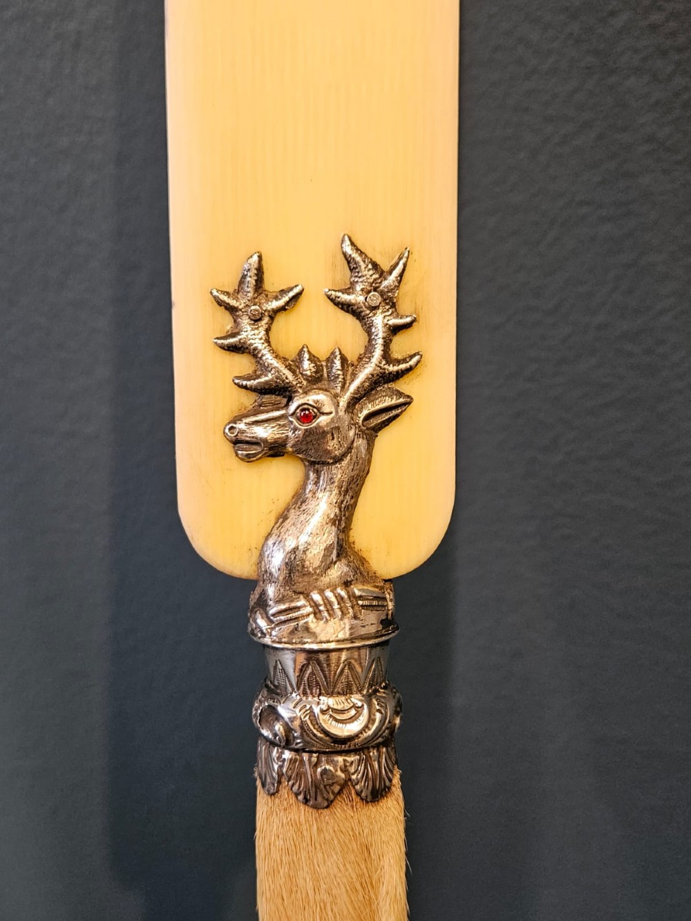 A Victorian page turner with a smooth cream blade, a silver deer motif at the base, and a taxidermy deer hoof handle. View II