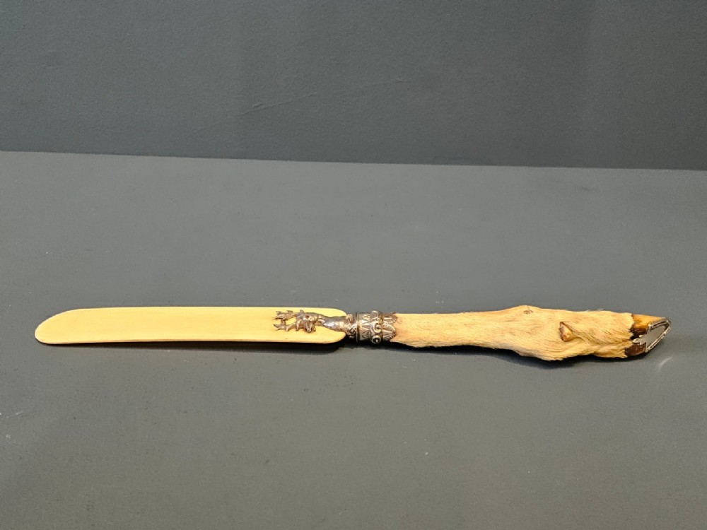 A Victorian page turner with a smooth cream blade, a silver deer motif at the base, and a taxidermy deer hoof handle. View III