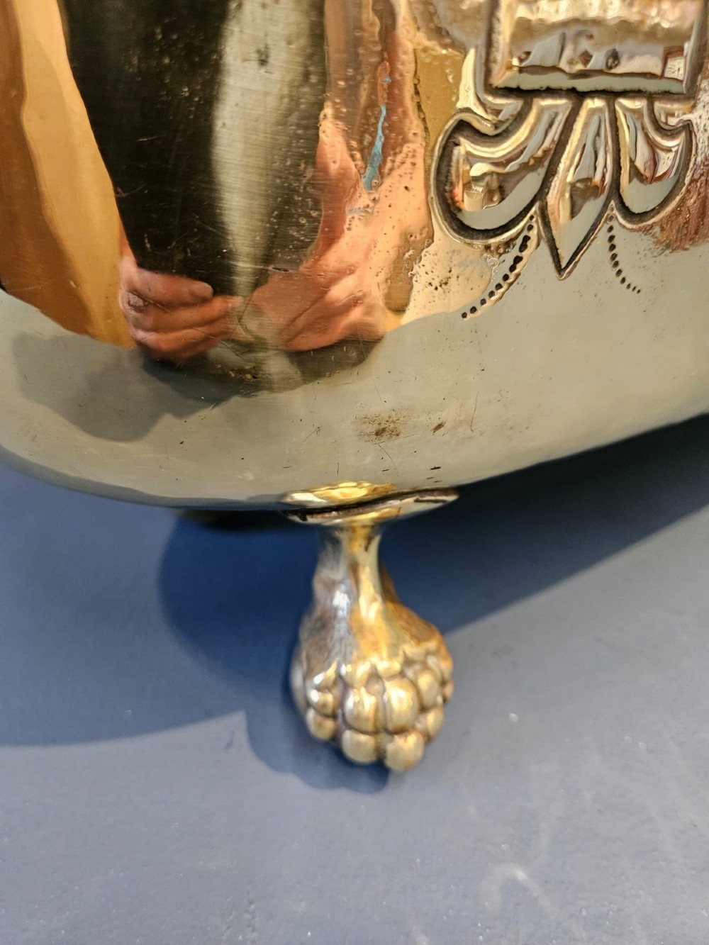 An oblong Victorian brass planter featuring an embossed armorial crest, fleur-de-lis motifs, side ring handles, and cast claw feet. View IV