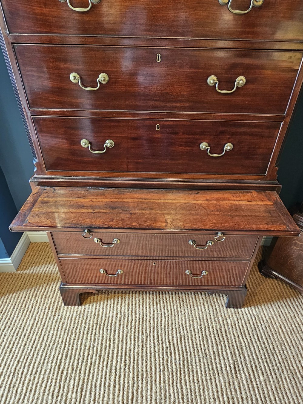 A George III mahogany chest on chest featuring two stacked drawer sections, swan-neck brass handles, dentil moulding, and bracket feet. View VI