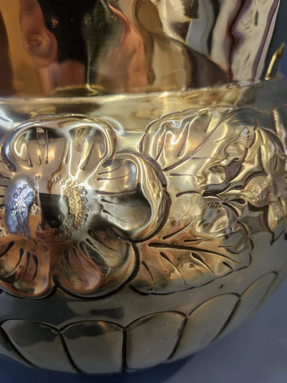 A polished Victorian brass jardiniere planter featuring embossed floral detailing around the upper band, fluted gadrooning on the lower body, and two side handles. View IV