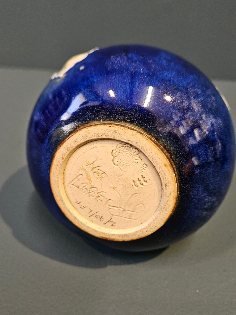 A pair of Victorian Doulton Lambeth stoneware ewers featuring cobalt blue glazed bodies, single handles, and raised foliage decoration in beige and ocher. View VI