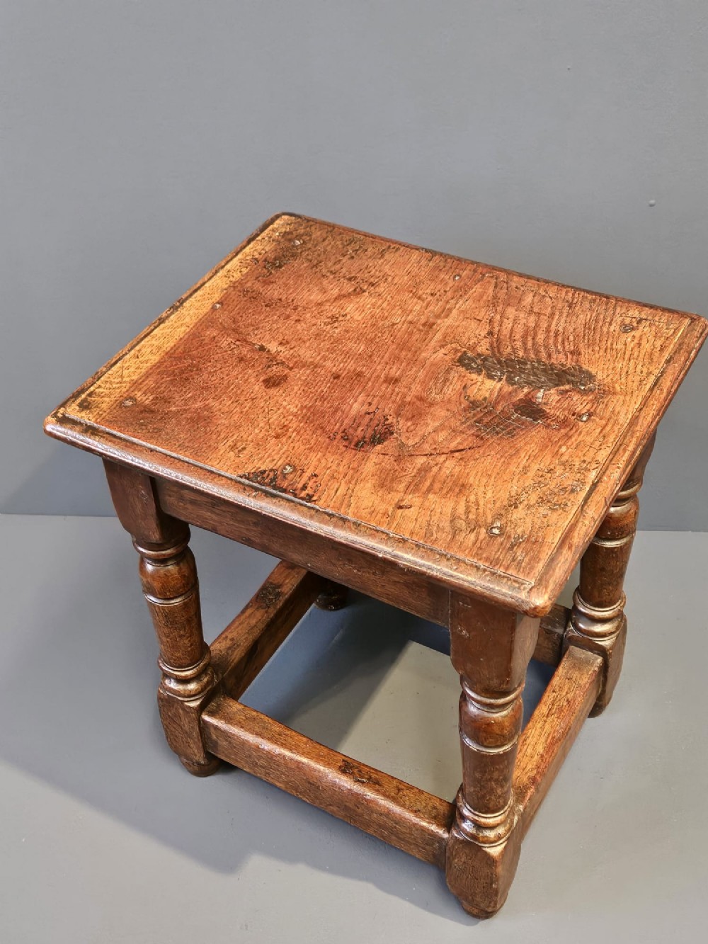A George III oak joint stool featuring turned legs, lower stretchers, and a moulded rectangular top. View II