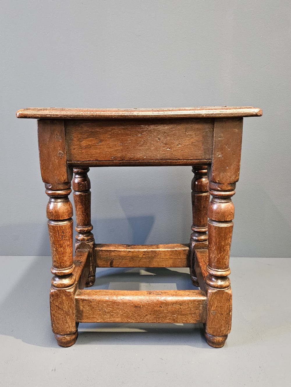 A George III oak joint stool featuring turned legs, lower stretchers, and a moulded rectangular top. View V