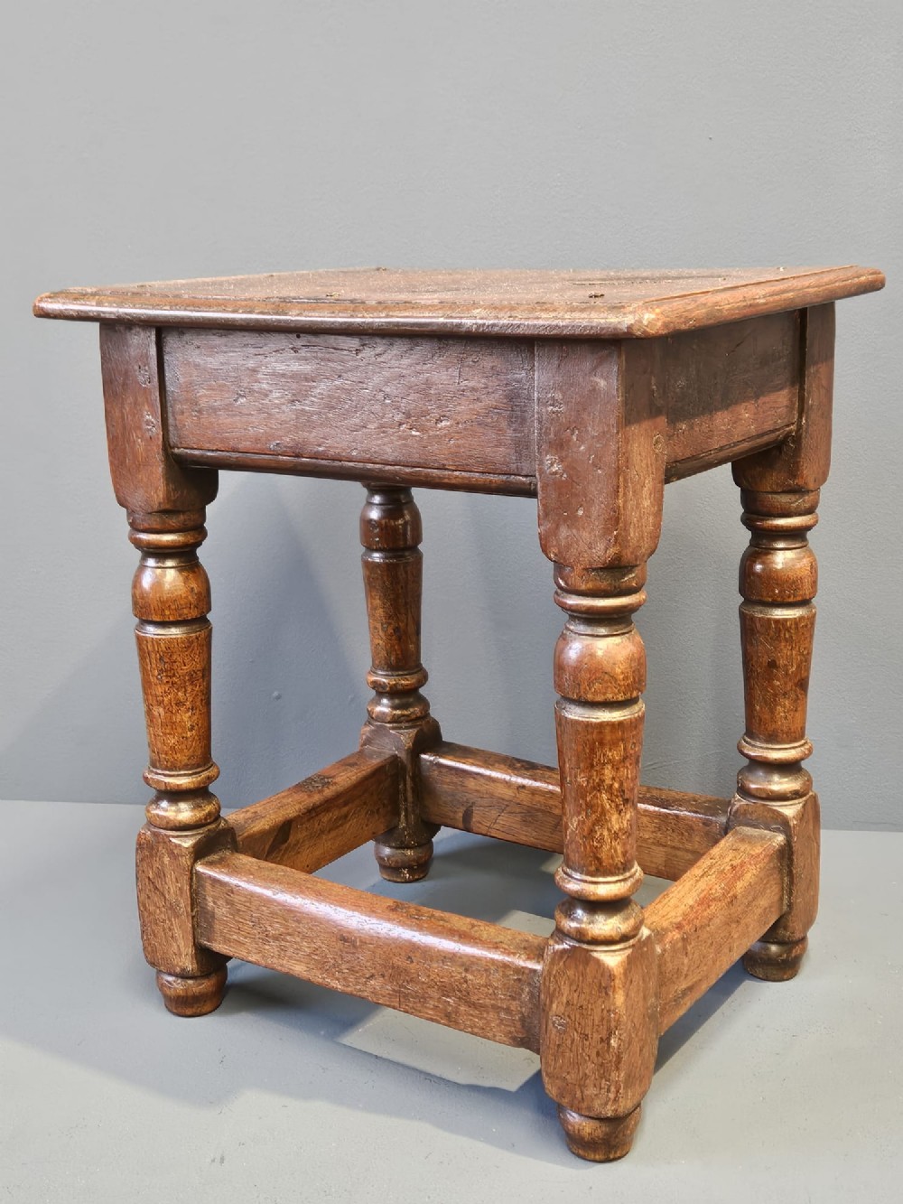 A George III oak joint stool featuring turned legs, lower stretchers, and a moulded rectangular top. View VI