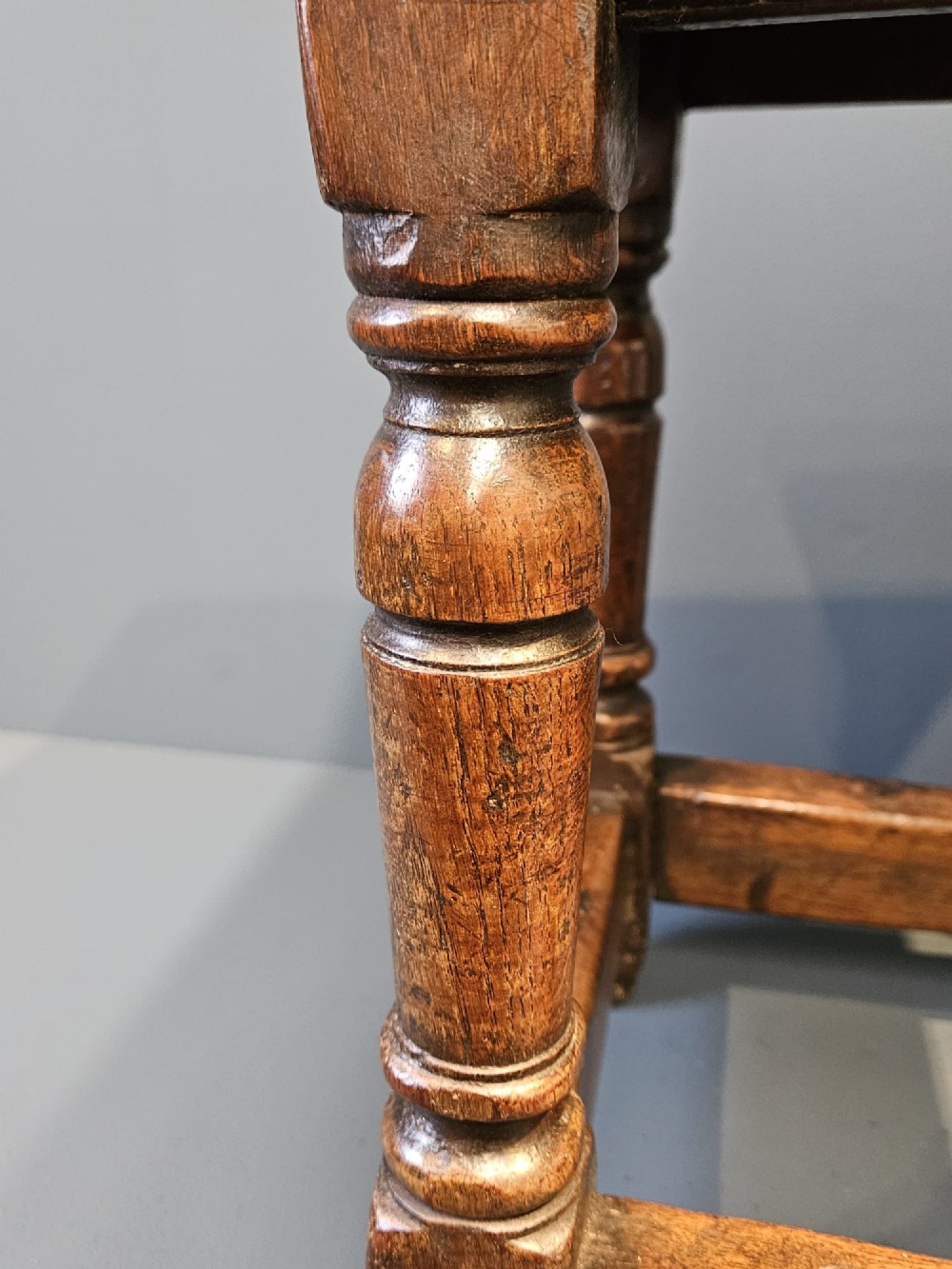 A George III oak joint stool featuring turned legs, lower stretchers, and a moulded rectangular top. View VII