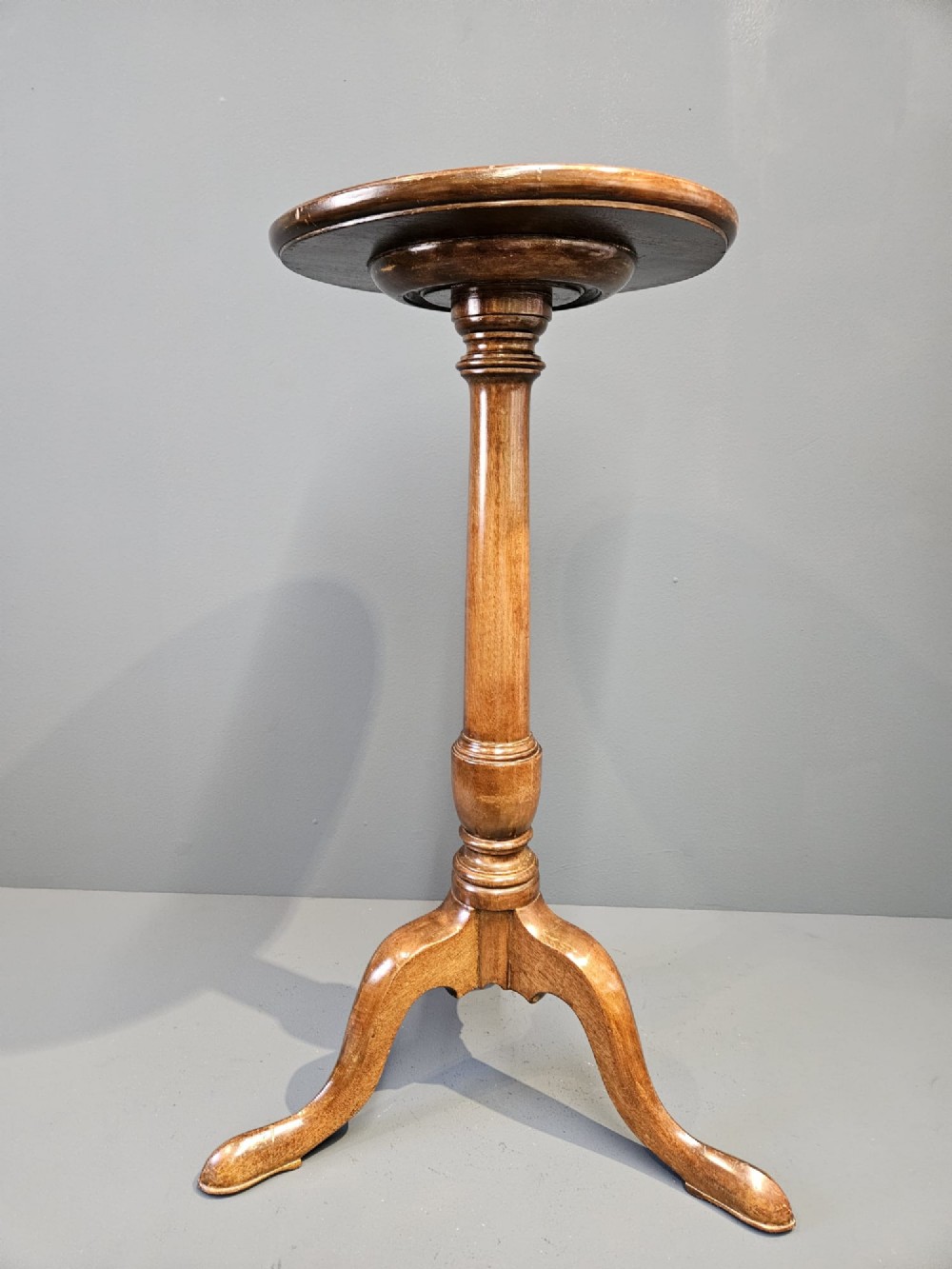 A Georgian mahogany wine table featuring a circular top with a moulded rim supported by a turned pedestal stem on tripod legs. View IV