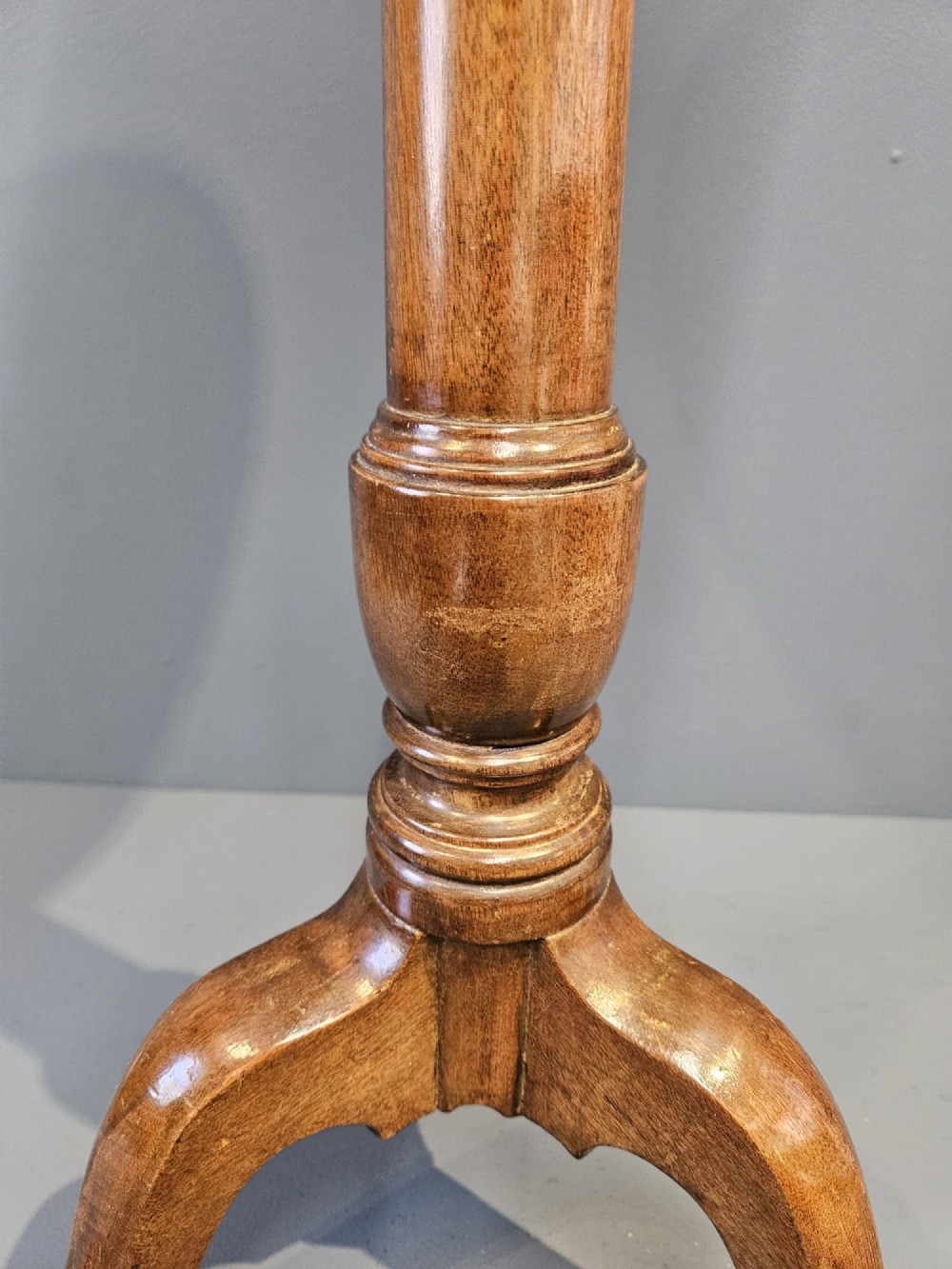 A Georgian mahogany wine table featuring a circular top with a moulded rim supported by a turned pedestal stem on tripod legs. View V