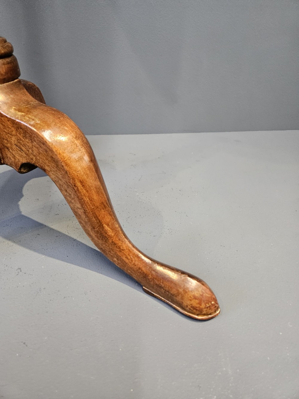 A Georgian mahogany wine table featuring a circular top with a moulded rim supported by a turned pedestal stem on tripod legs. View VI