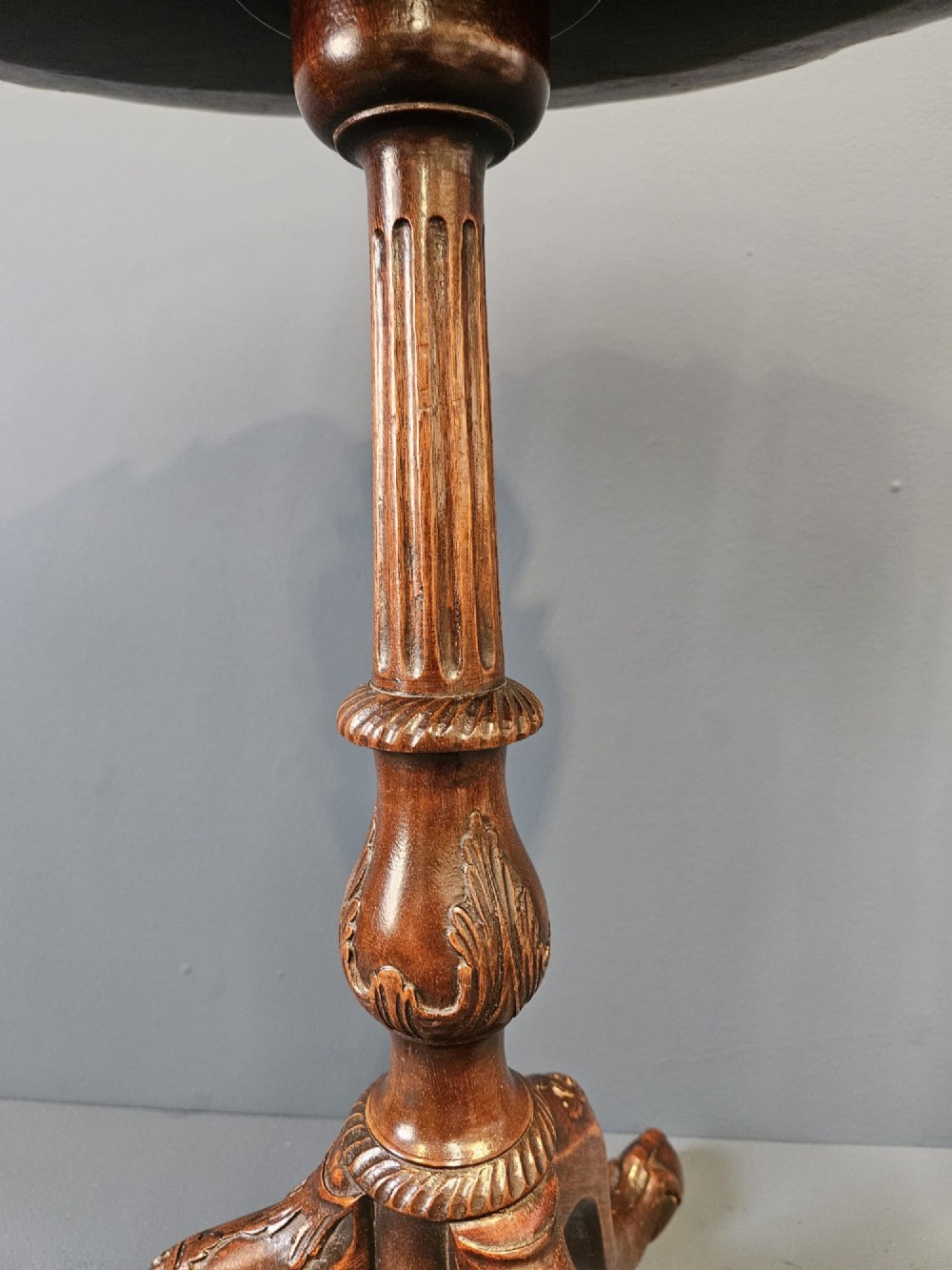 An Edwardian mahogany occasional table featuring an oval top with a raised piecrust edge, supported by a carved central pedestal and tripod cabriole legs. View IV
