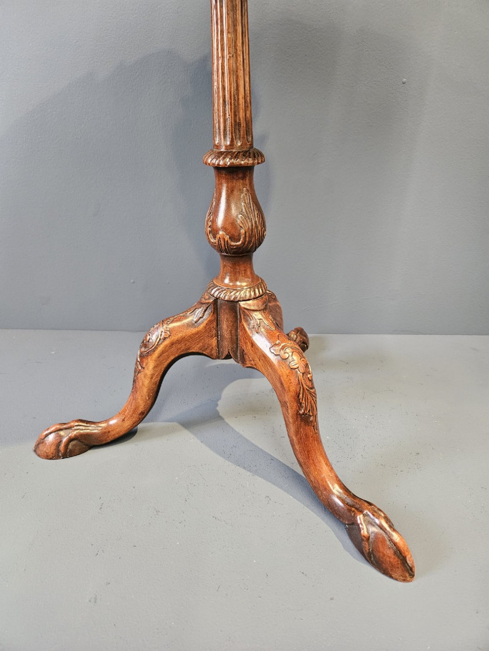 An Edwardian mahogany occasional table featuring an oval top with a raised piecrust edge, supported by a carved central pedestal and tripod cabriole legs. View V