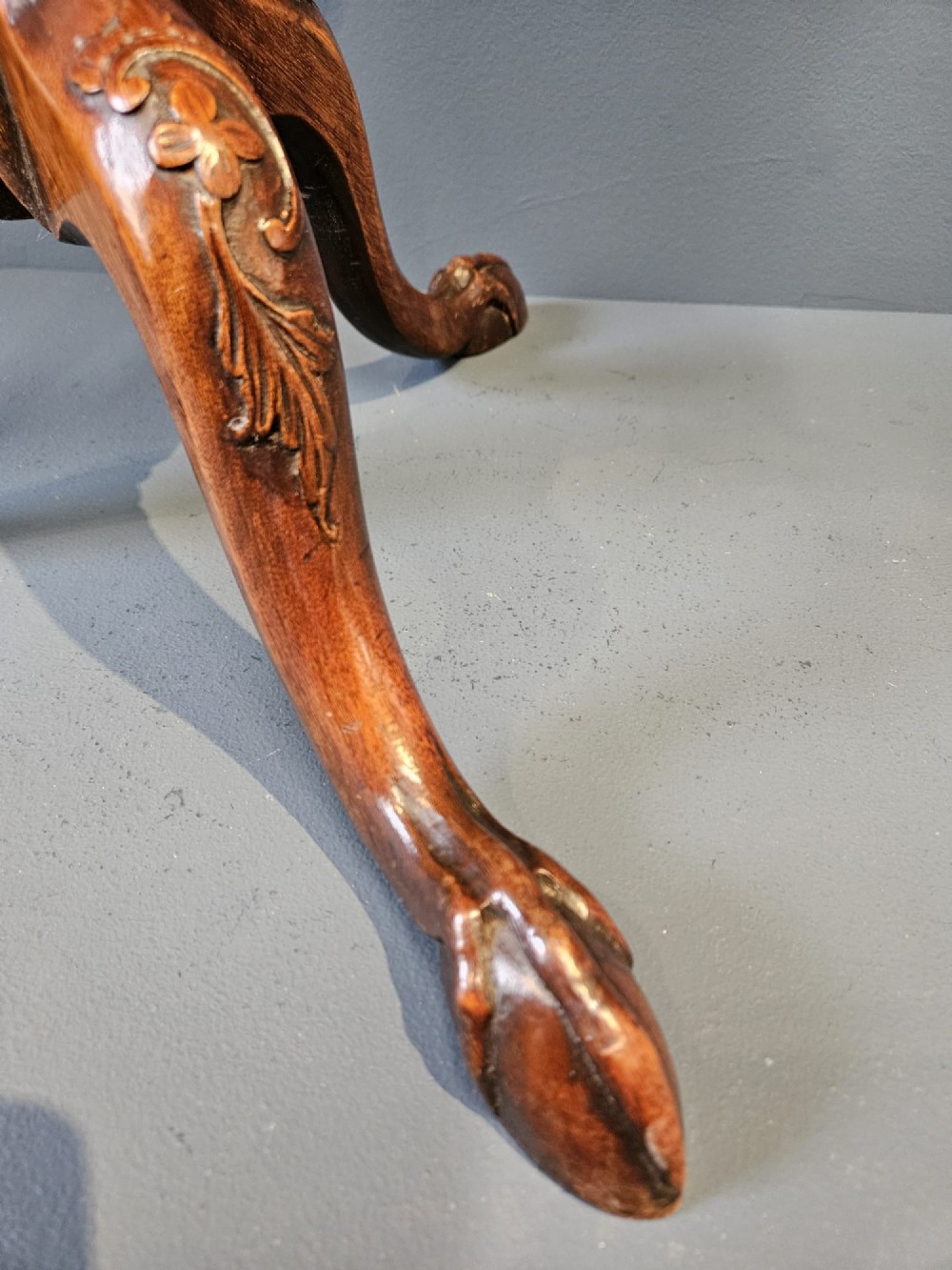 An Edwardian mahogany occasional table featuring an oval top with a raised piecrust edge, supported by a carved central pedestal and tripod cabriole legs. View VI