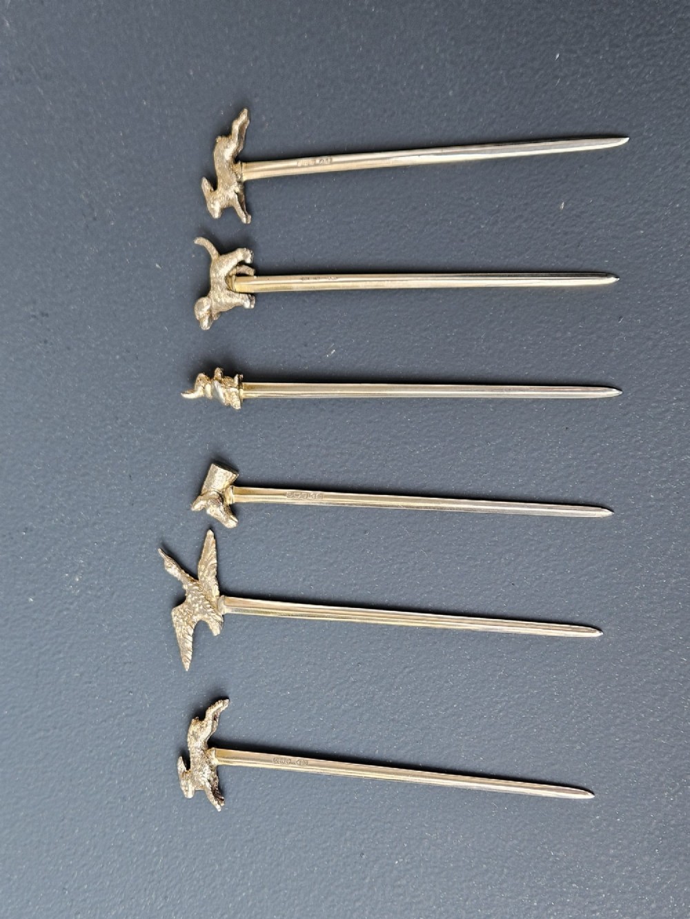 A set of six silver cocktail sticks featuring cast animal finials, arranged inside a fitted presentation box with cream silk and dark velvet lining. View II