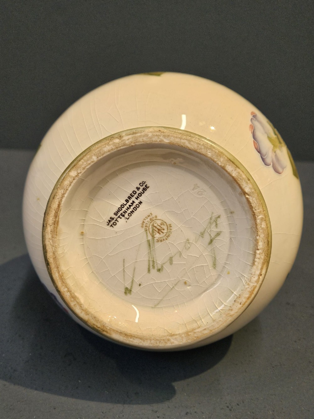 An Art Nouveau Macintyre Moorcroft earthenware vase featuring hand-painted tubelined pansy motifs on a cream ground with a green flared rim. View VII