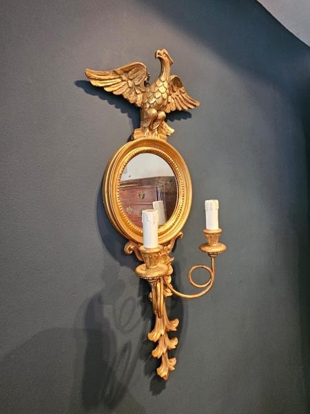 A pair of gold gilt wall sconces featuring eagle tops, circular convex mirrors, and twin candle arms. View III