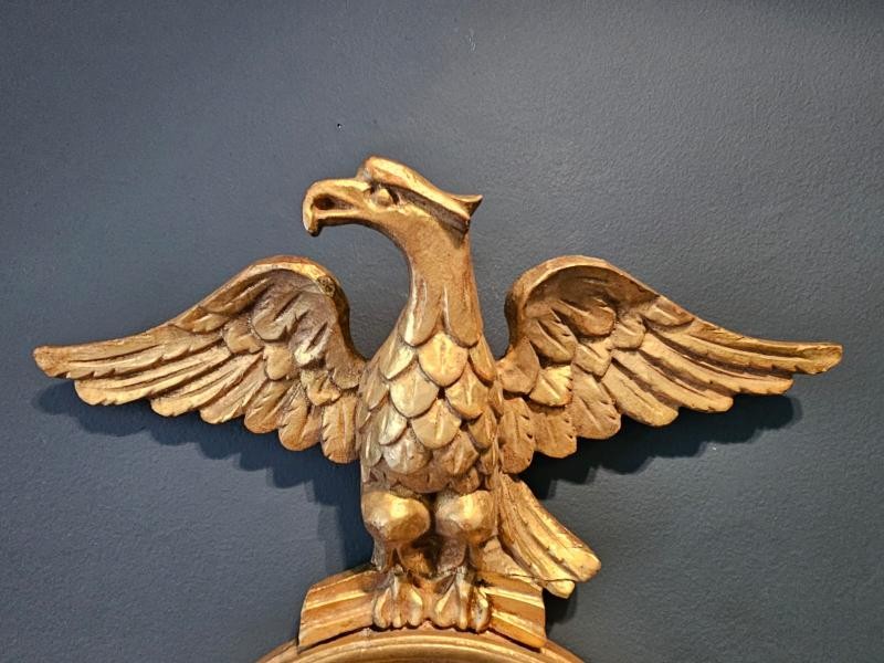 A pair of gold gilt wall sconces featuring eagle tops, circular convex mirrors, and twin candle arms. View IV