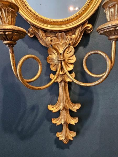 A pair of gold gilt wall sconces featuring eagle tops, circular convex mirrors, and twin candle arms. View V