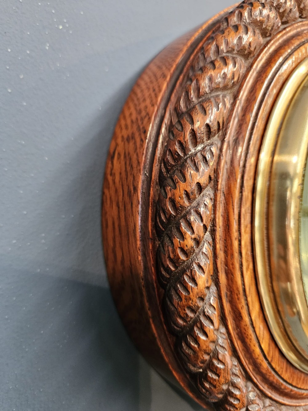 A circular Victorian aneroid barometer set in a carved oak rope-twist frame with a silvered engraved dial and a brass bezel. View VI