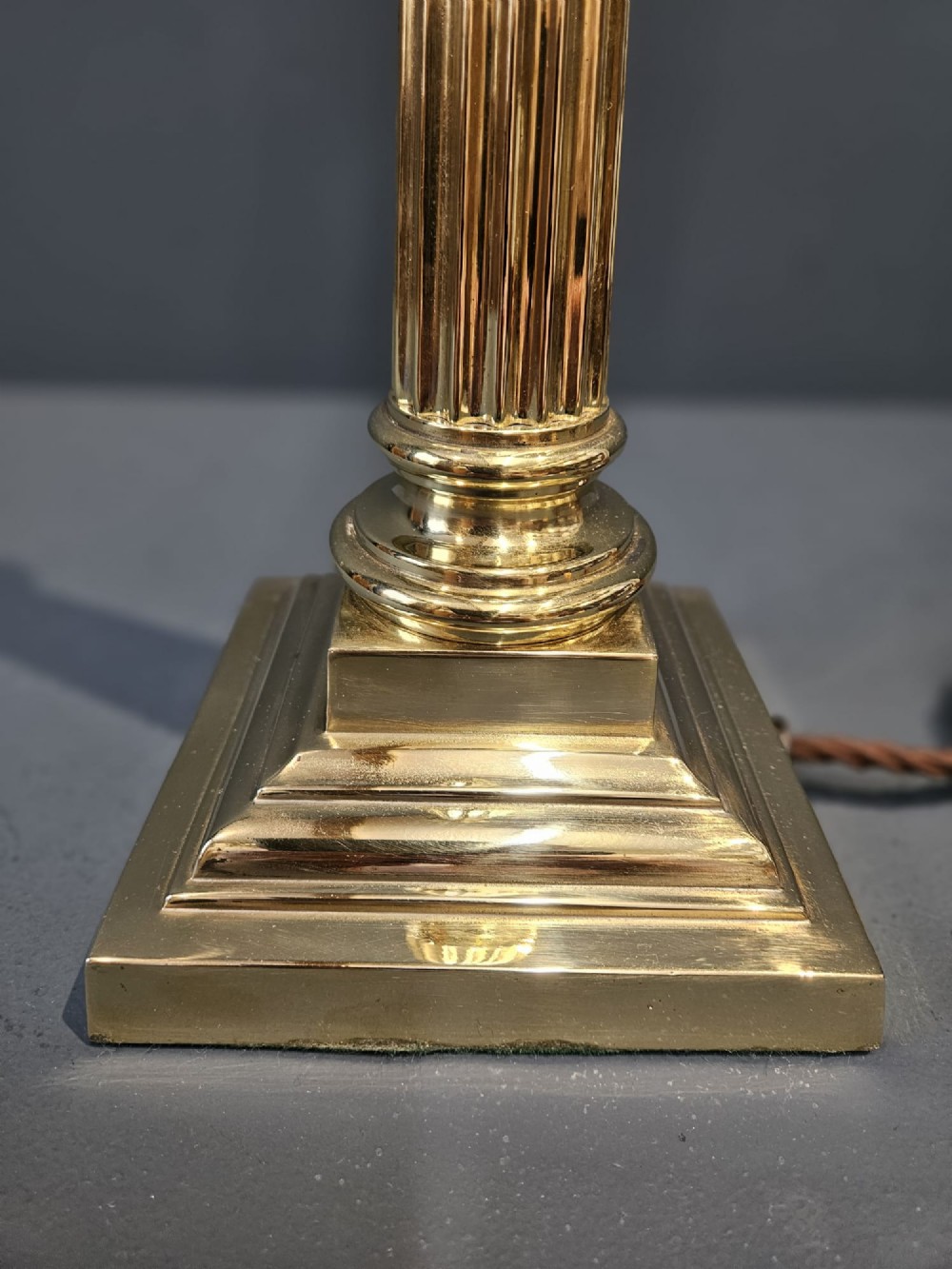 A late Victorian brass table lamp featuring a tapered reeded column stem set upon a stepped square base. View III