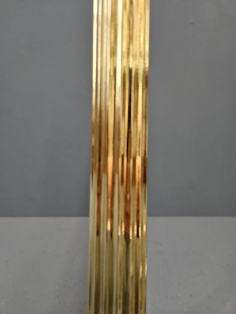 A late Victorian brass table lamp featuring a tapered reeded column stem set upon a stepped square base. View IV