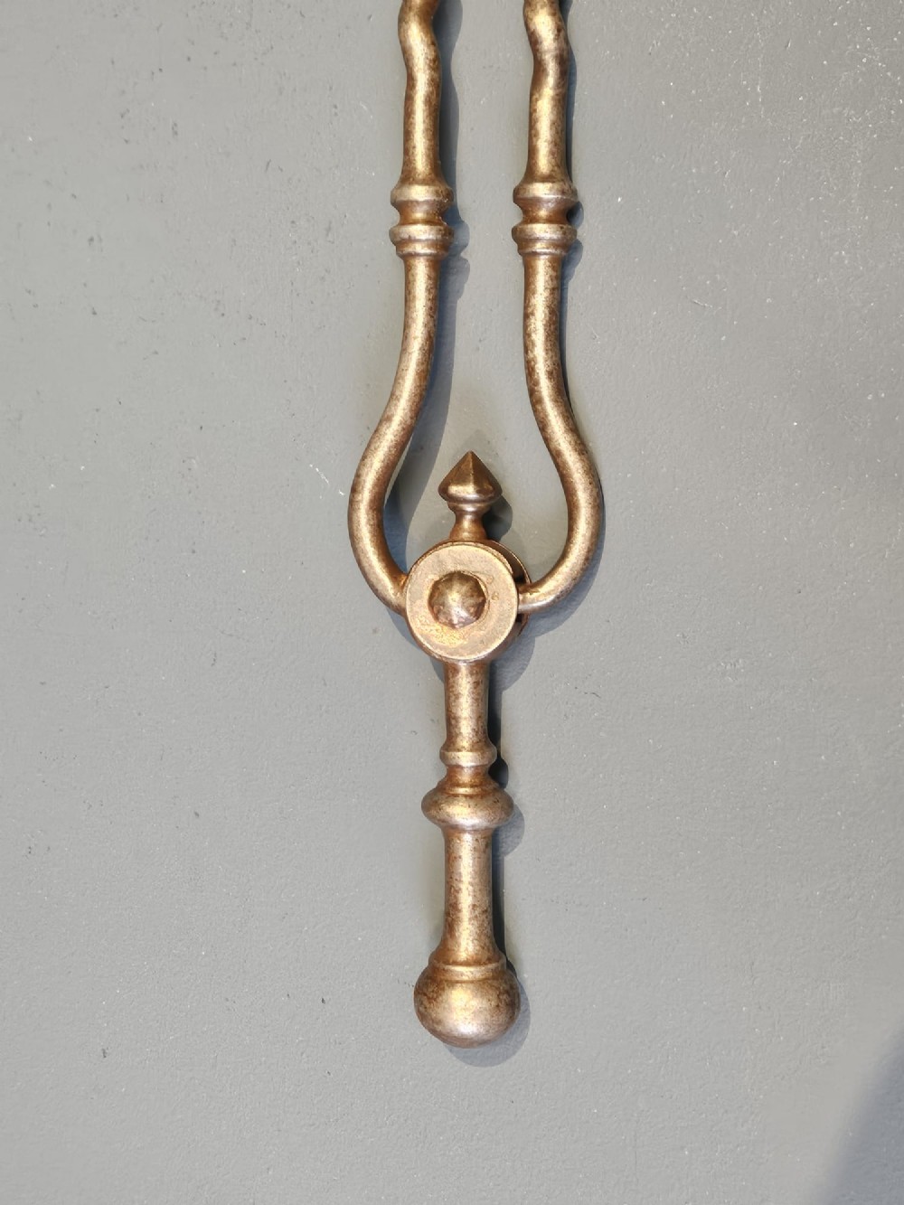 A set of three Georgian steel fire irons featuring barley twist shafts, turned urn finials, and a pierced decorative shovel blade. View III