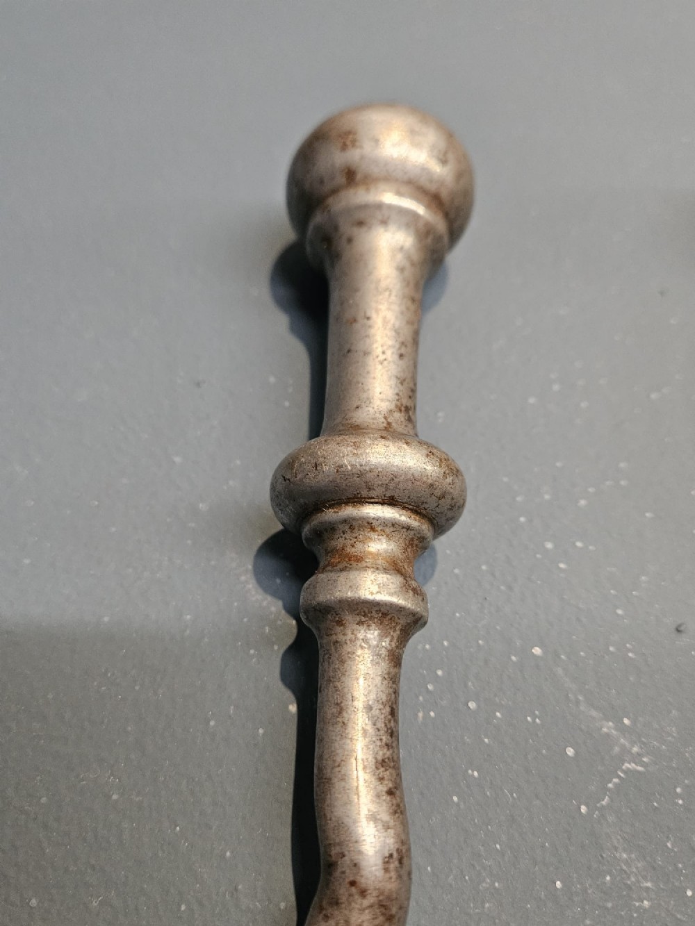 A set of three Georgian steel fire irons featuring barley twist shafts, turned urn finials, and a pierced decorative shovel blade. View V