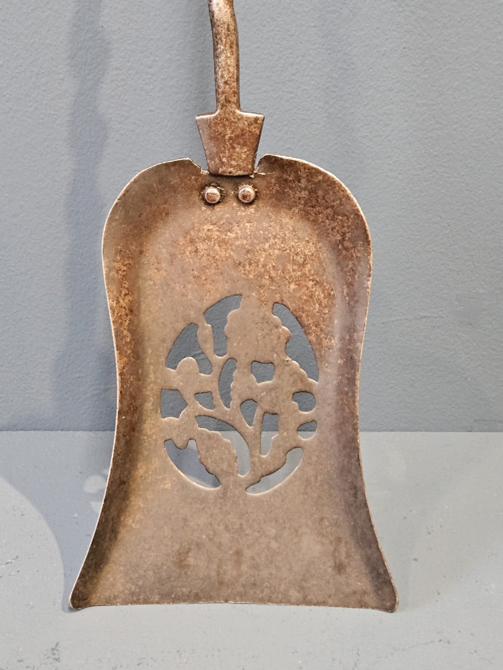 A set of three Georgian steel fire irons featuring barley twist shafts, turned urn finials, and a pierced decorative shovel blade. View VII