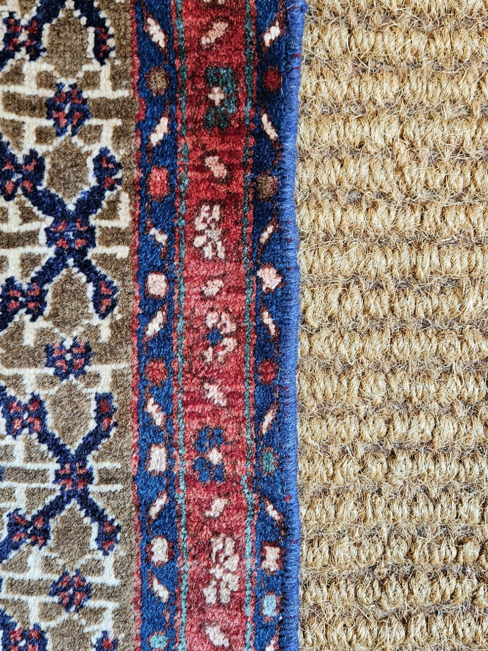 A small rectangular hand-knotted wool rug featuring a central star medallion, geometric lattice field, and deep red and blue borders. View II