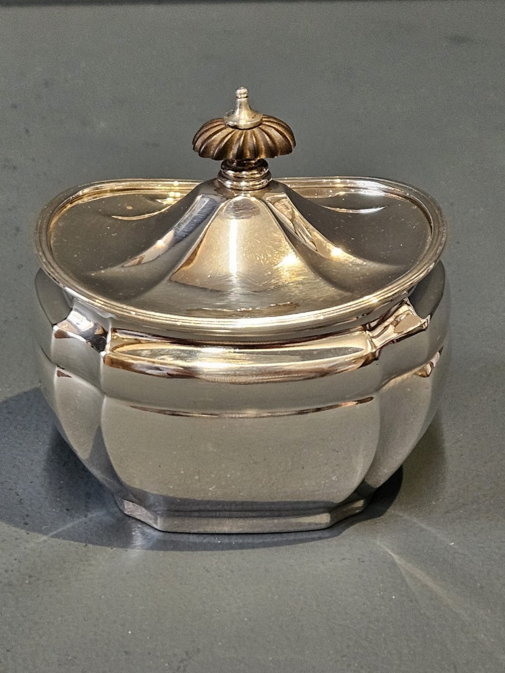 A shaped Victorian silver tea caddy featuring a lobed body, a stepped cover, and a gadrooned finial. View II