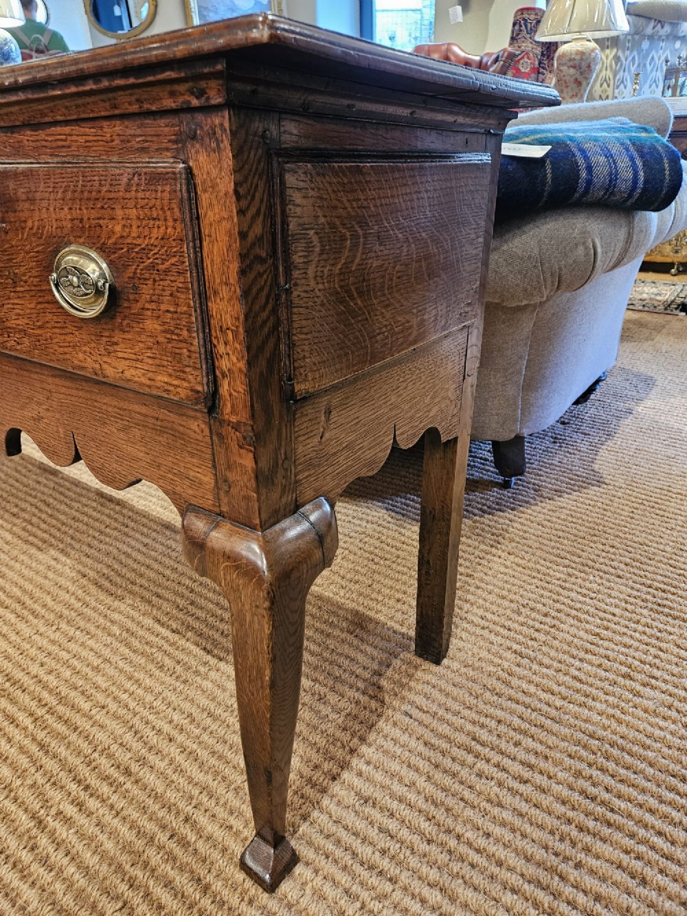 A George II oak dresser base featuring three drawers, brass handles, a shaped apron, and four cabriole legs. View VI