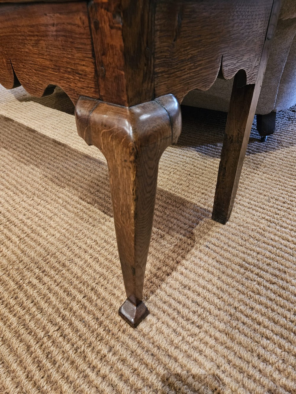 A George II oak dresser base featuring three drawers, brass handles, a shaped apron, and four cabriole legs. View VII