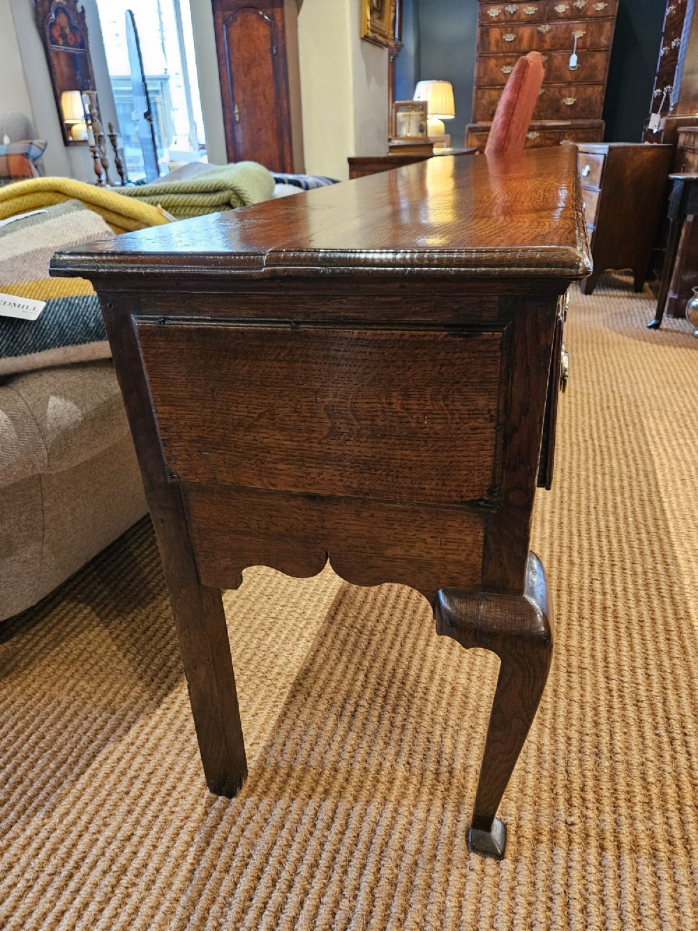 A George II oak dresser base featuring three drawers, brass handles, a shaped apron, and four cabriole legs. View IX