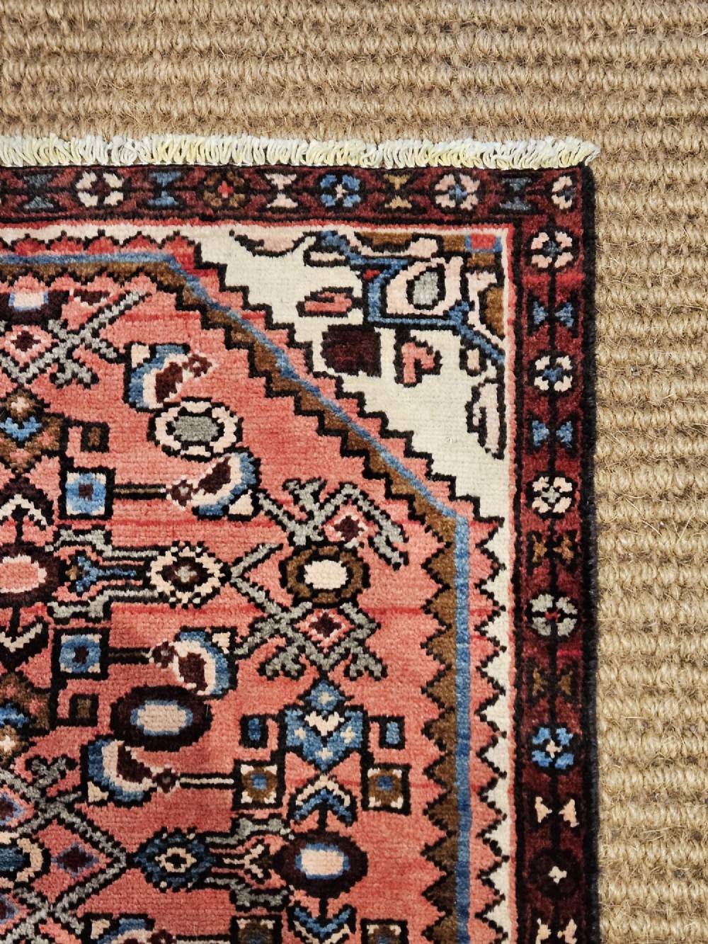 A long hand-knotted pure wool runner rug featuring geometric medallions in rose pink, navy blue, and cream. View II