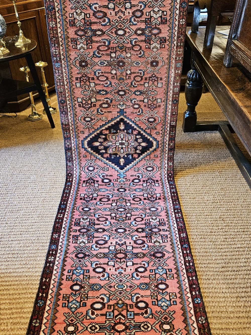 A long hand-knotted pure wool runner rug featuring geometric medallions in rose pink, navy blue, and cream. View VI