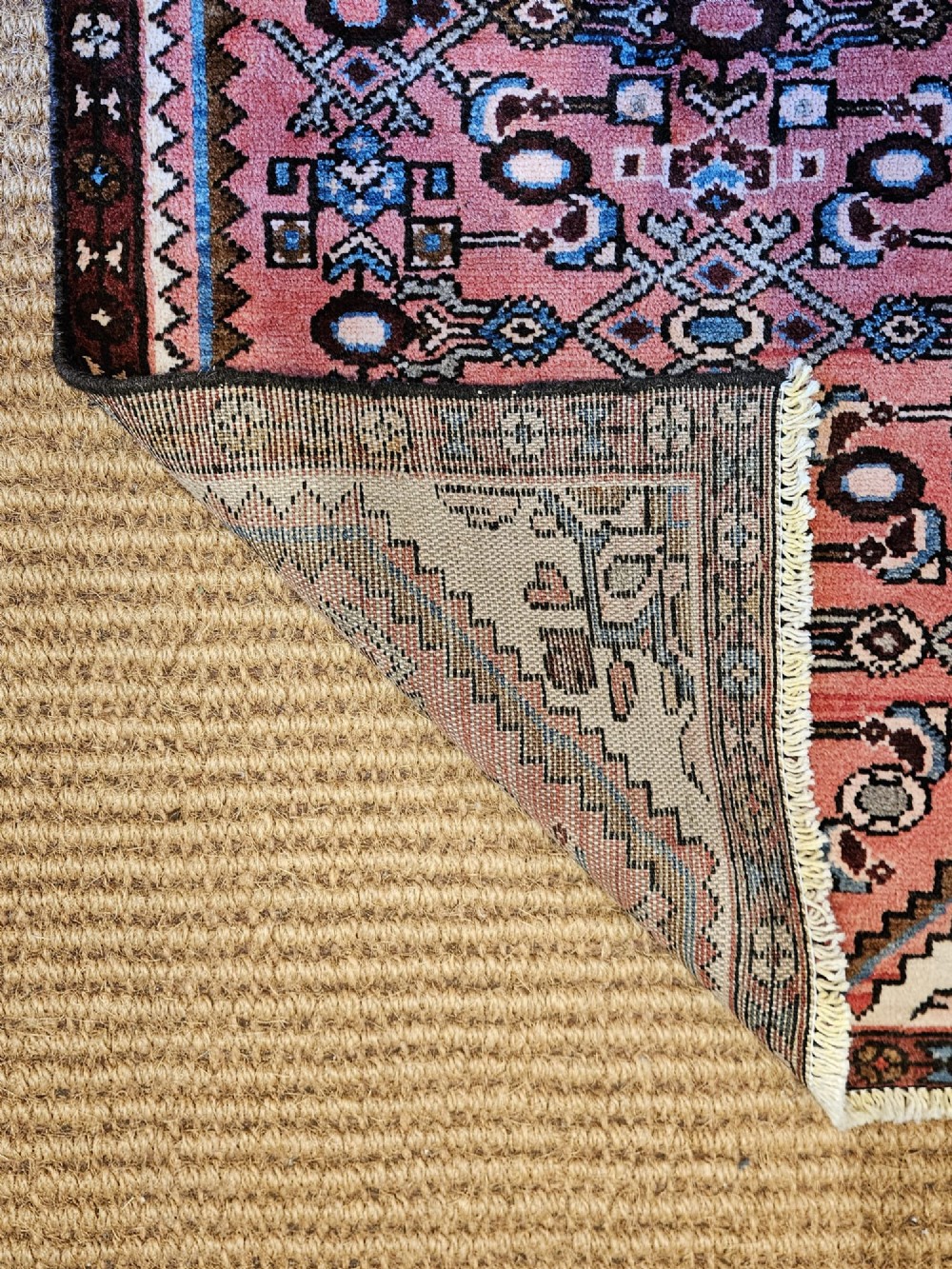 A long hand-knotted pure wool runner rug featuring geometric medallions in rose pink, navy blue, and cream. View VIII