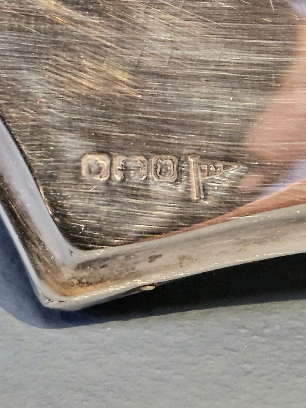An Edwardian sterling silver photo frame featuring swept concave sides, a shaped crest, polished silver surface, and portrait orientation. View VI