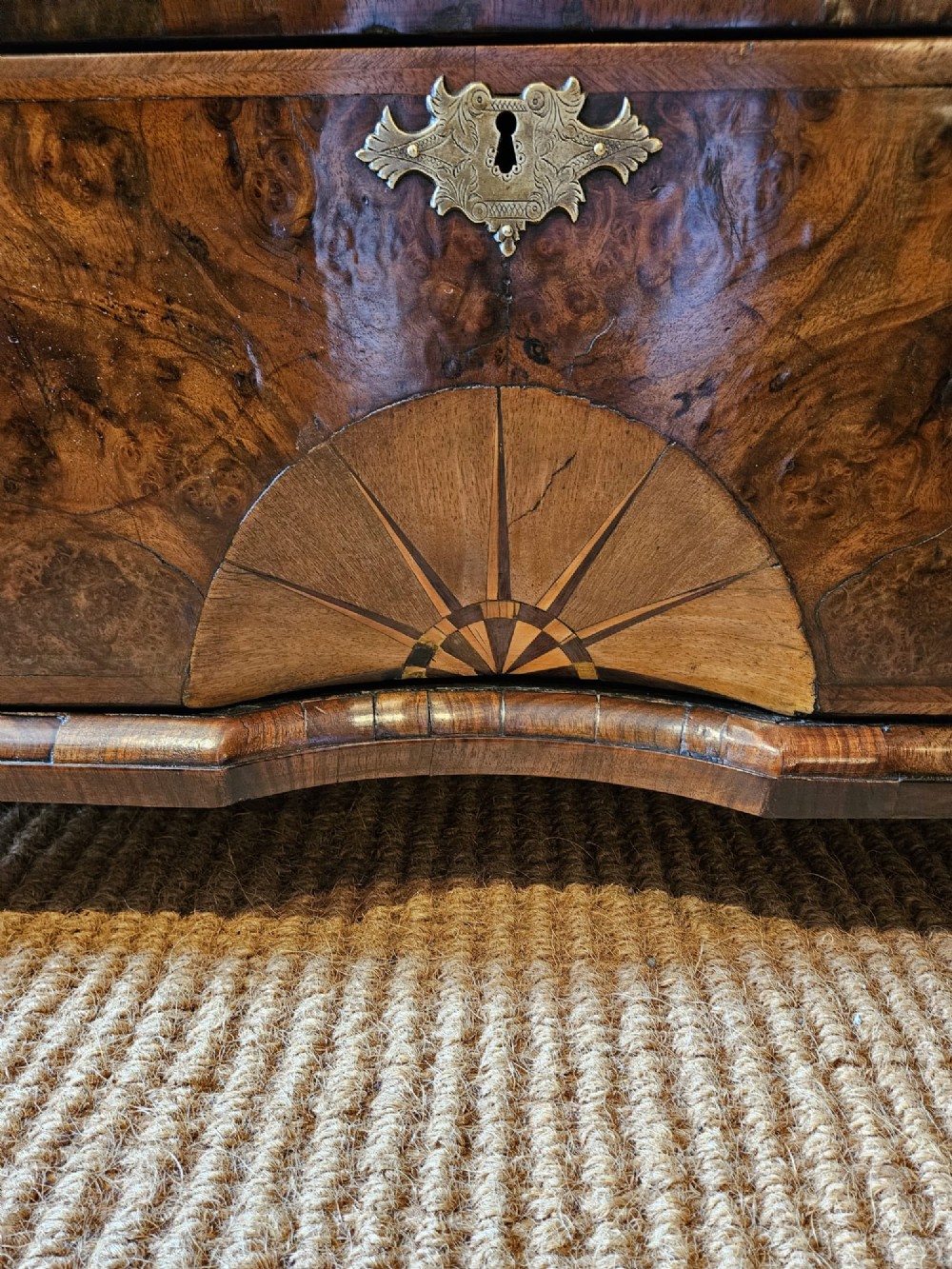 A George I burr walnut chest on chest featuring multiple stacked drawers with brass escutcheons and a dished sunburst motif on the lower drawer. View II