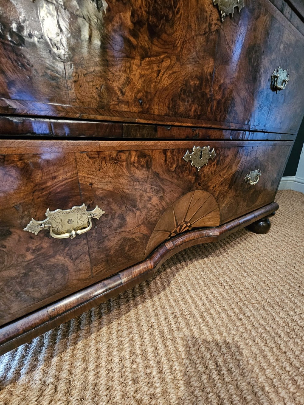 A George I burr walnut chest on chest featuring multiple stacked drawers with brass escutcheons and a dished sunburst motif on the lower drawer. View VI