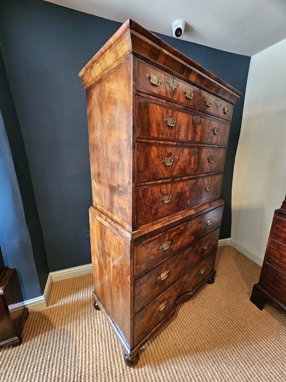 A George I burr walnut chest on chest featuring multiple stacked drawers with brass escutcheons and a dished sunburst motif on the lower drawer. View VII