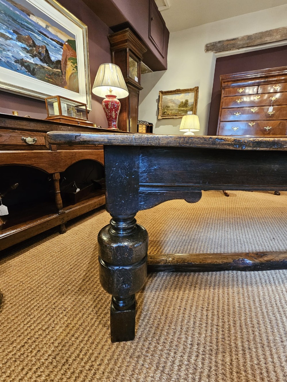 A long George II dark oak refectory dining table featuring a solid plank top, turned legs, and low stretcher rails. View VIII
